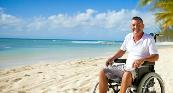 man in wheelchair overlooking beautiful beach