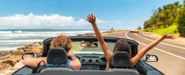 Women driving on holiday by beach